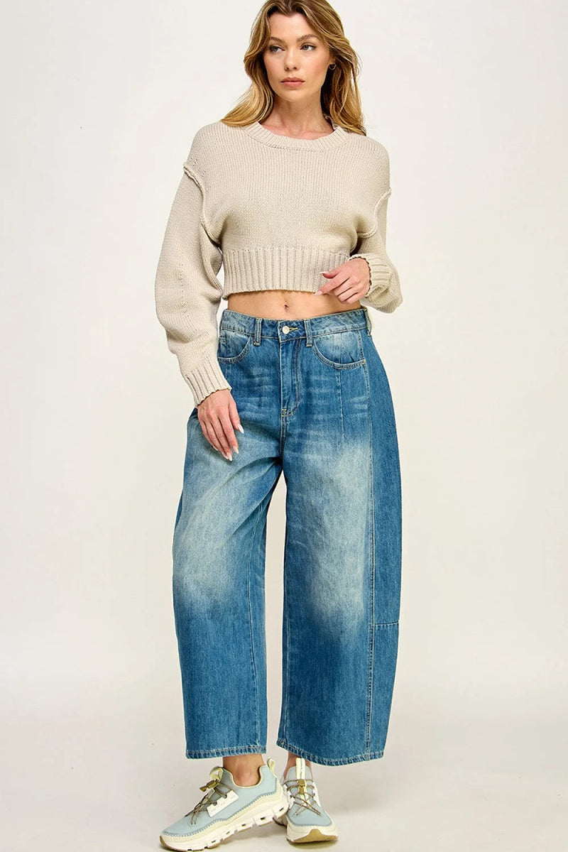 Woman showcasing a Minimal Pullover Sweater paired with wide-leg blue jeans