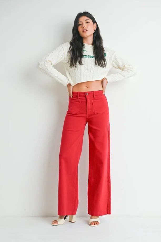 Woman in a cropped white sweater and bright red mini patch pocket wide jeans