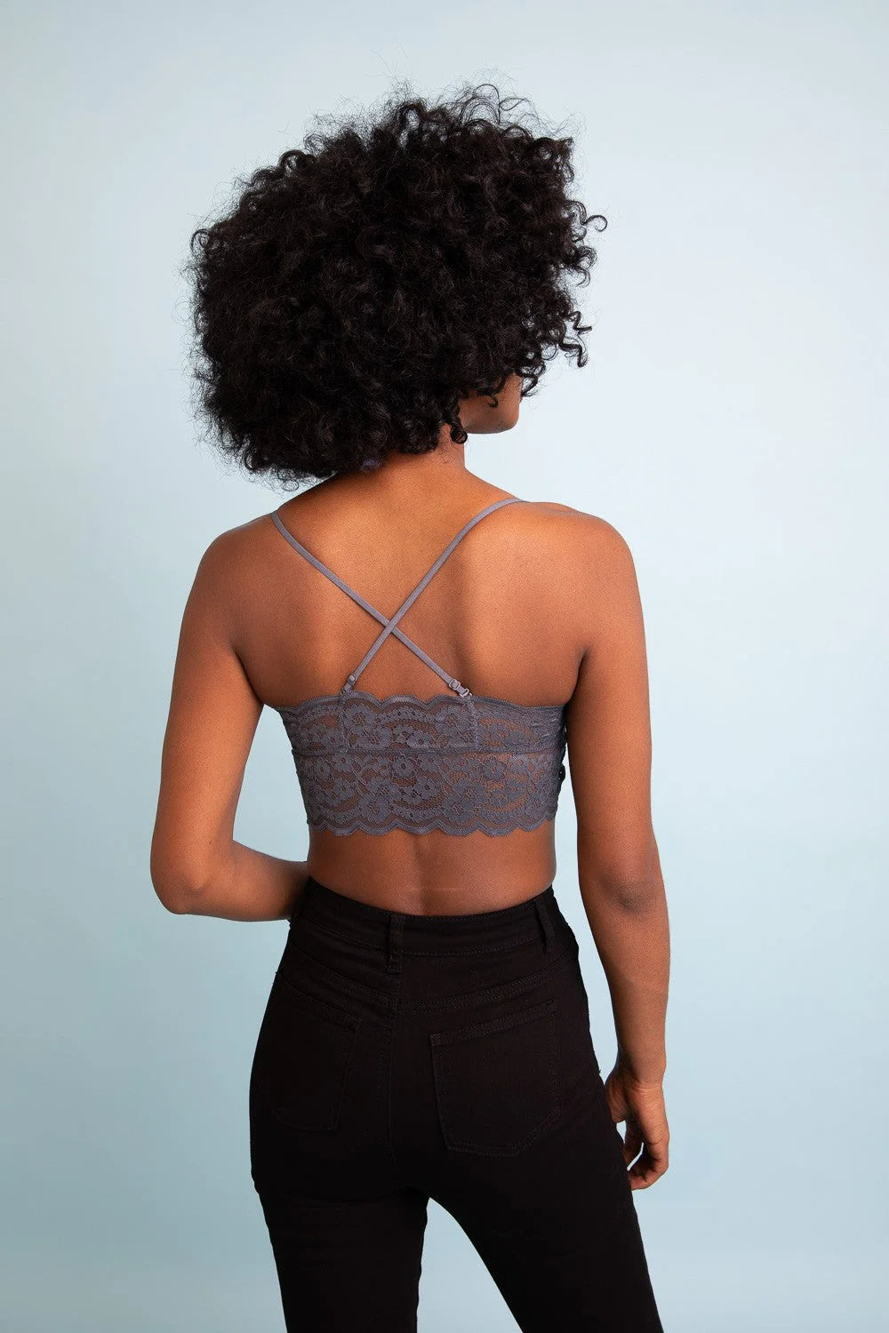 Woman with curly afro hair in a grey bra top featuring a wide lace bandeau design