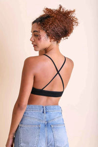 Woman with curly hair modeling a Crochet Lace High Neck Bralette in black