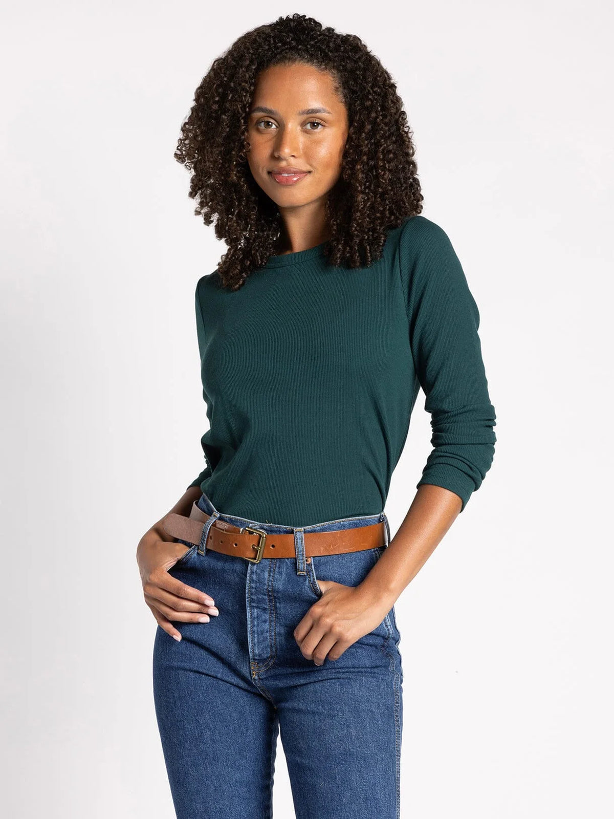 Woman with curly hair in a green sweater showcasing the micro ribbed ultra soft long sleeve top