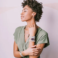 Woman with curly hair in sage green shirt showcasing SUEDE/STONE WRAP with magnetic clasp