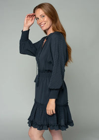 Woman wearing a dark blue boho dolman sleeve tie front mini dress