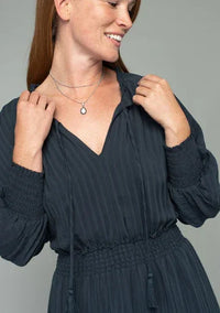 Woman wearing a dark blue boho dolman sleeve mini dress with tie front and smocked waist