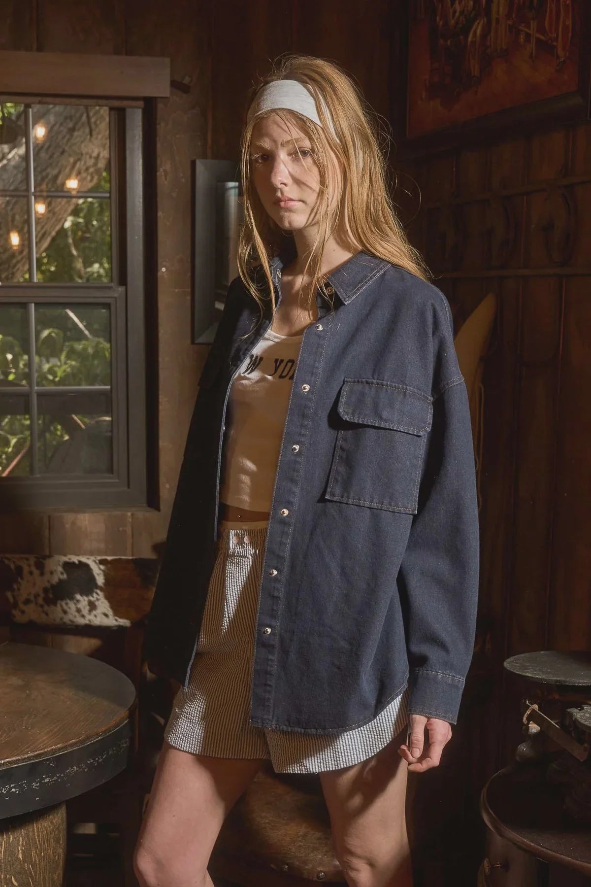 Woman wearing dark denim button-down long sleeve shirt from Shop Daisy women’s boho chic clothing