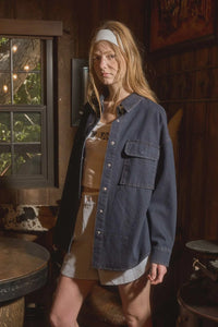 Woman wearing dark denim button-down long sleeve shirt from Shop Daisy women’s boho chic clothing