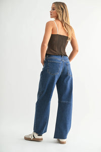 Woman wearing dark brown ruched corset top and wide leg denim barrel jeans