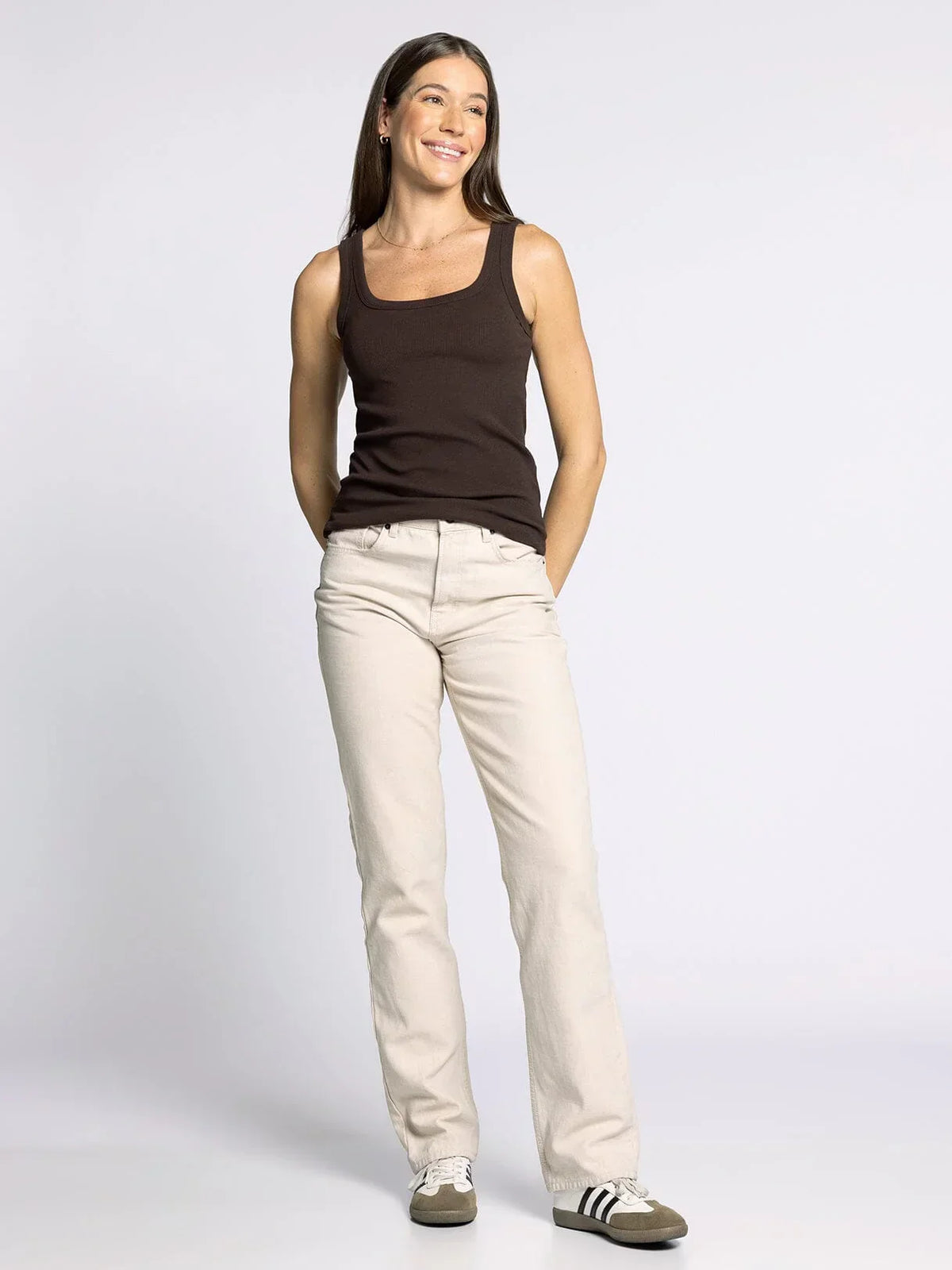 Woman wearing the THREAD AND SUPPLY CLARKSON TANK in dark brown with light beige pants