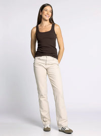 Woman wearing the THREAD AND SUPPLY CLARKSON TANK in dark brown with light beige pants