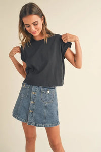 Woman in a dark round neck cuffed sleeve top and denim skirtStylish outfit for casual wear