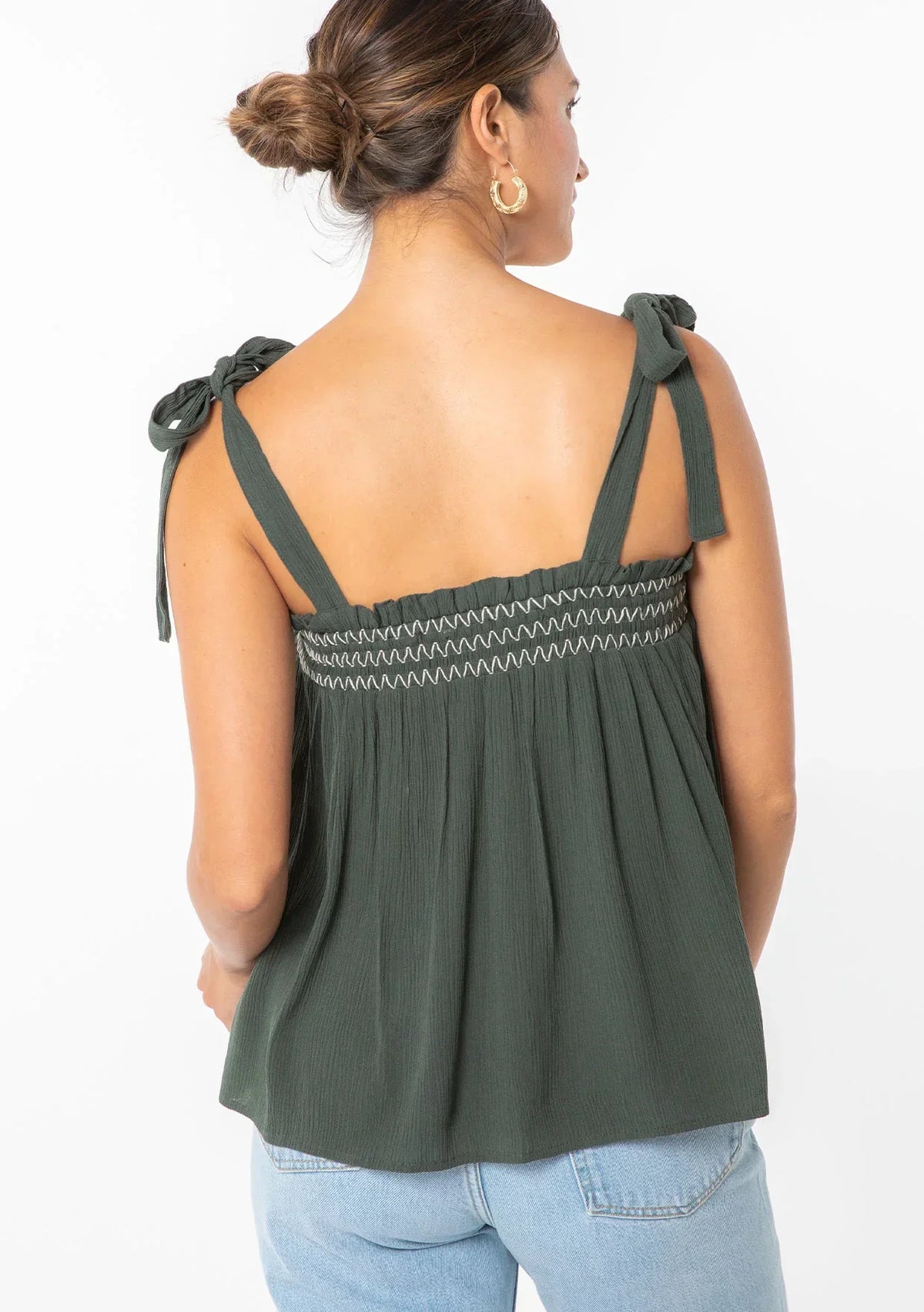 Woman wearing bohemian tie shoulder smocked tank top with shoulder ties in dark green