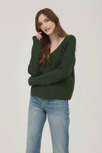 Woman in dark green V Neck Long Sleeve Ribbed Sweater paired with blue jeans