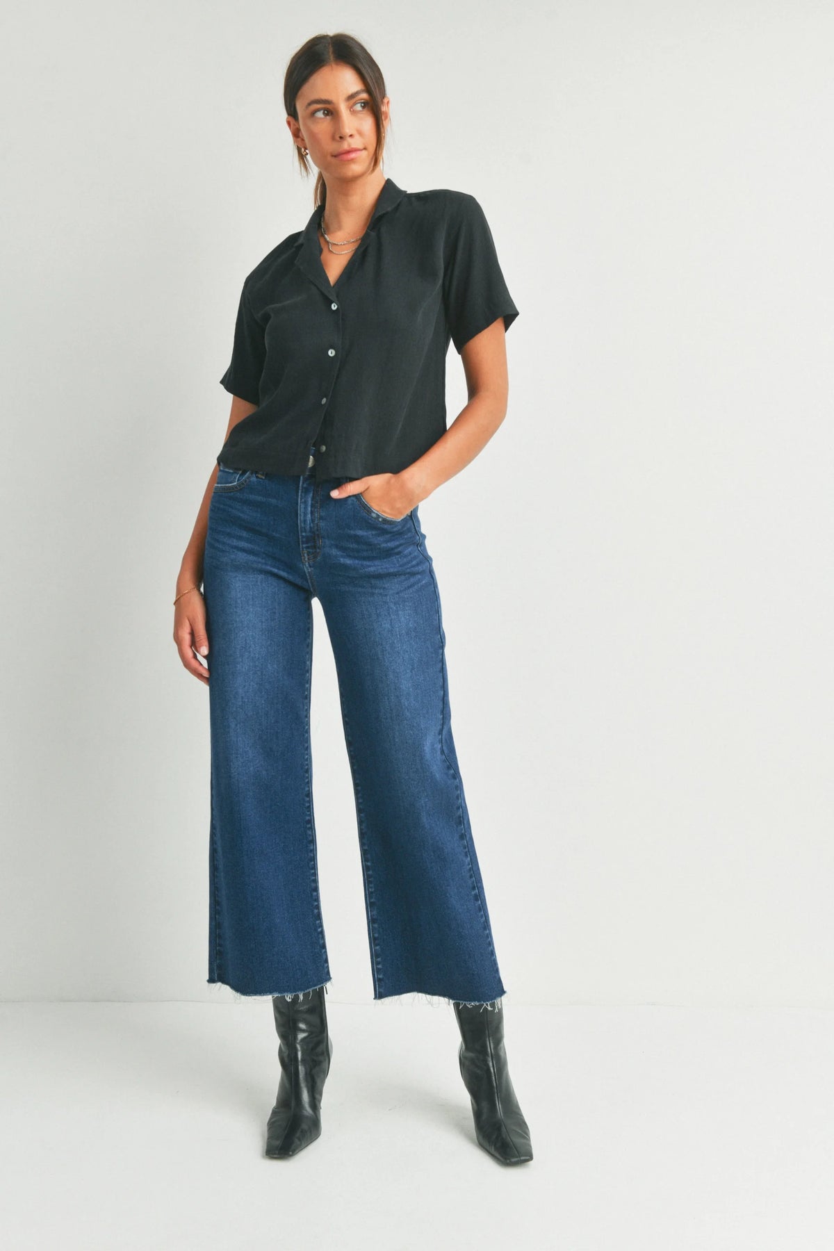 Woman in dark short-sleeved shirt and blue wide-leg jeans for a boho free spirit style