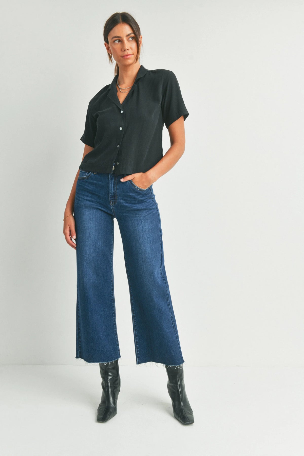 Woman in a dark shirt and blue wide-leg jeans exuding boho free spirit style