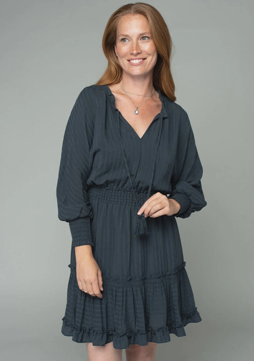 Woman wearing a teal boho dolman sleeve tie front mini dress with ruffled tiers