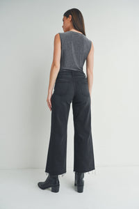 Woman in flowy dark wide-leg trousers and gray sleeveless top showcasing boho style