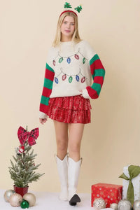 Woman in festive attire showcasing a holly jolly sweater with a red skirt and accessories