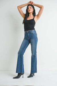 Woman in medium rise waist flare denim jeans and a black tank top