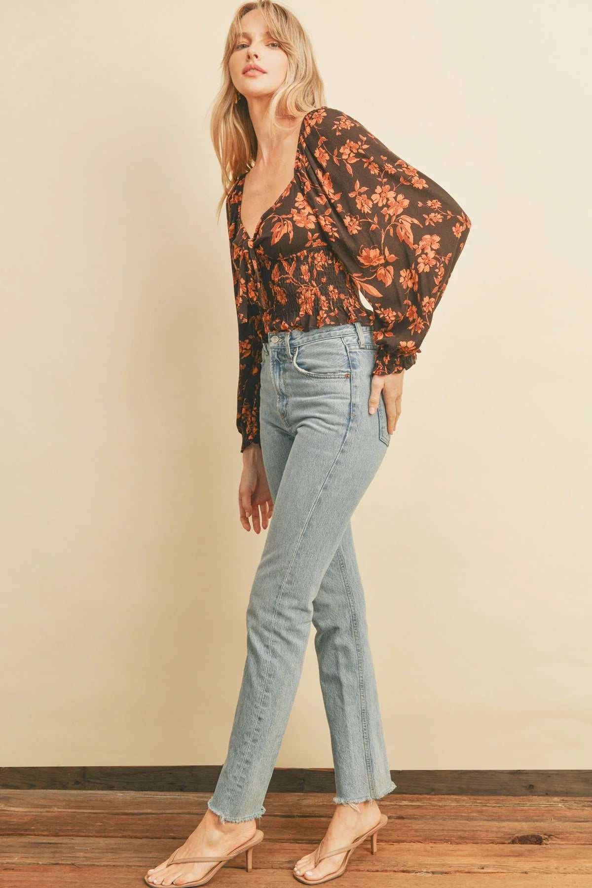 Woman in a floral blouse and light blue jeans featuring a Chocolate Sweetheart Smocked design