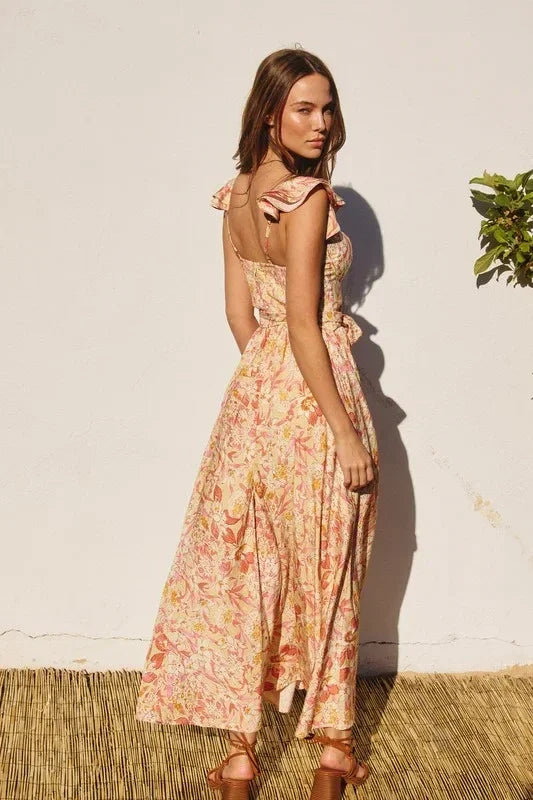 Woman in floral dress, standing on straw mat, wearing sunny days corset top maxi dress