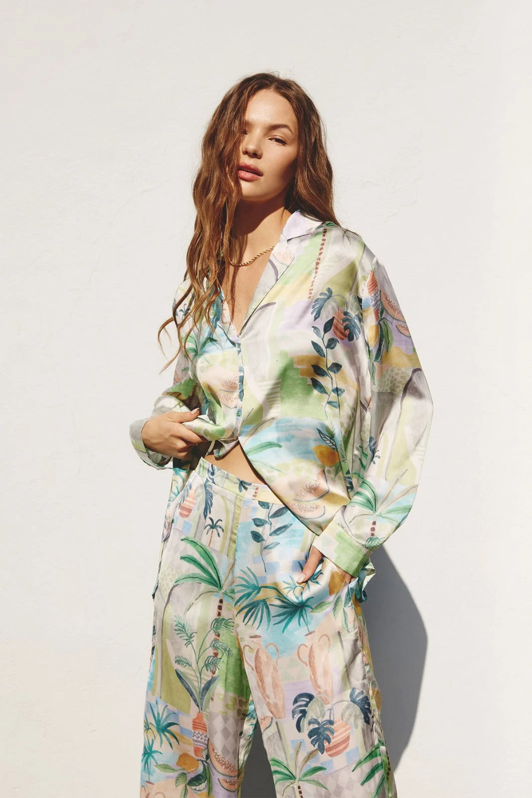 Woman in floral print boho pajamas with flowy white shirt from OUT OF OFFICE set