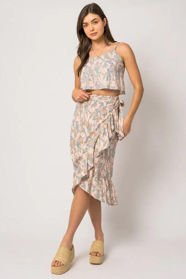 Woman in a wrap shirring floral midi skirt and matching crop top outfit