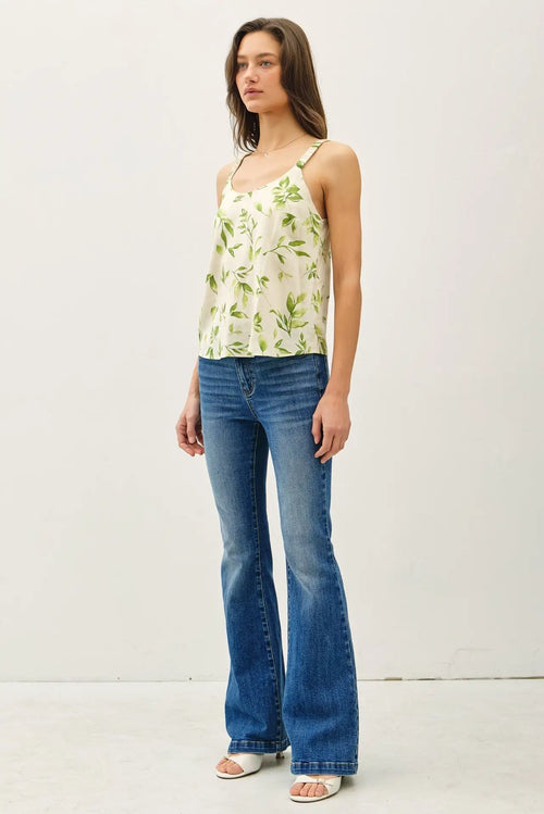 Woman wearing a breezy floral print elastic straps tank top with flared jeans