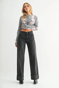 Woman wearing high rise cuffed wide leg jeans with gray argyle cardigan and black boots