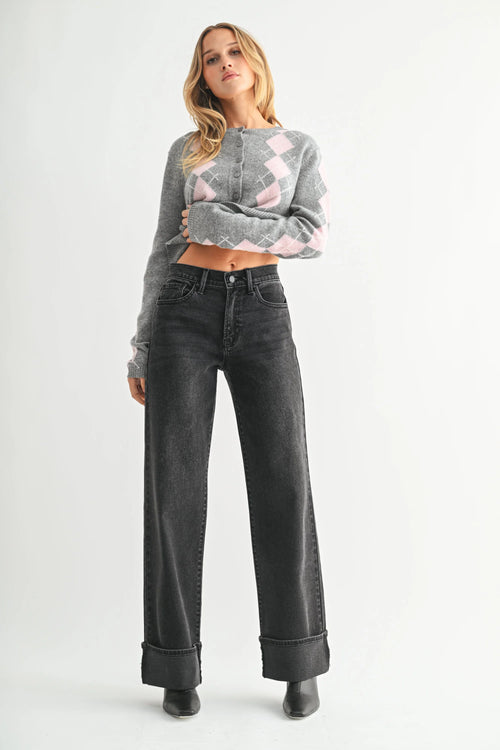 Woman wearing high rise cuffed wide leg jeans with gray argyle cardigan and black boots