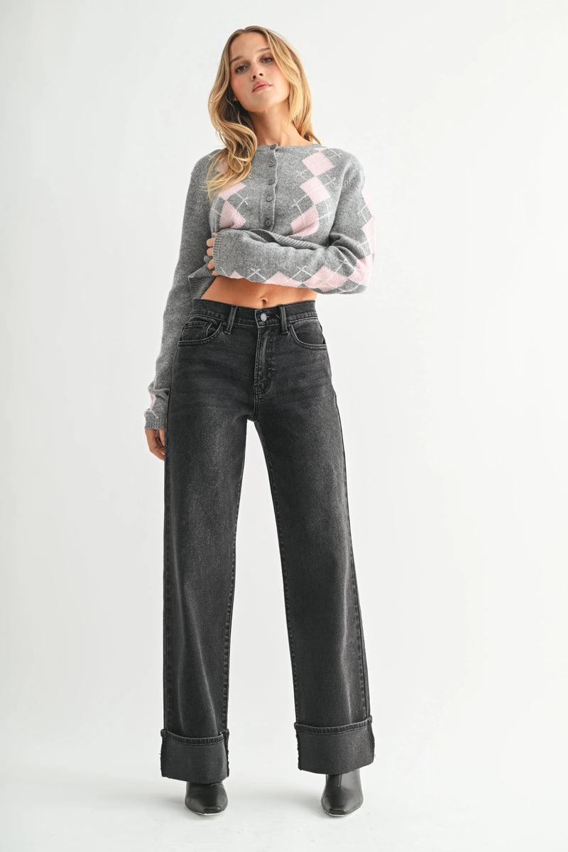 Woman wearing high rise cuffed wide leg jeans with gray argyle cardigan and black boots