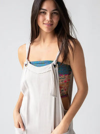 Woman in gray overalls showcasing a FULL BOHO BANDEAU HEADBAND from Shop Daisy’s collection