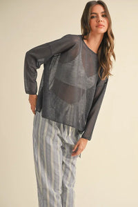 Woman in gray long-sleeved top and striped pants from Shop Daisy, women’s boho chic clothing