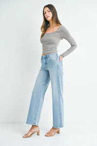 Woman in gray off-shoulder top and light blue slim wide leg jeans, stylish outfit