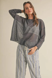 Woman in gray oversized sweater and striped pants from Shop Daisy’s women’s boho chic clothing