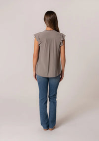 Woman in gray crinkle gauze top and blue jeans, showcasing a boho, flowy style