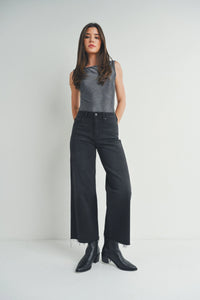 Woman in gray sleeveless top and black wide-leg pants showcases boho style with free spirit flair