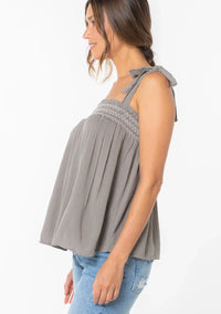 Woman wearing bohemian tie shoulder smocked tank top with light wash jeans