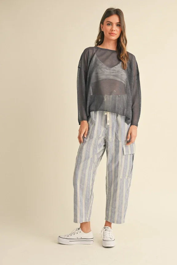 Woman in gray sweater and striped pants showcasing women’s boho chic clothing from Shop Daisy