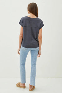 Woman in a gray breezy linen tee and light blue jeans showcasing casual style