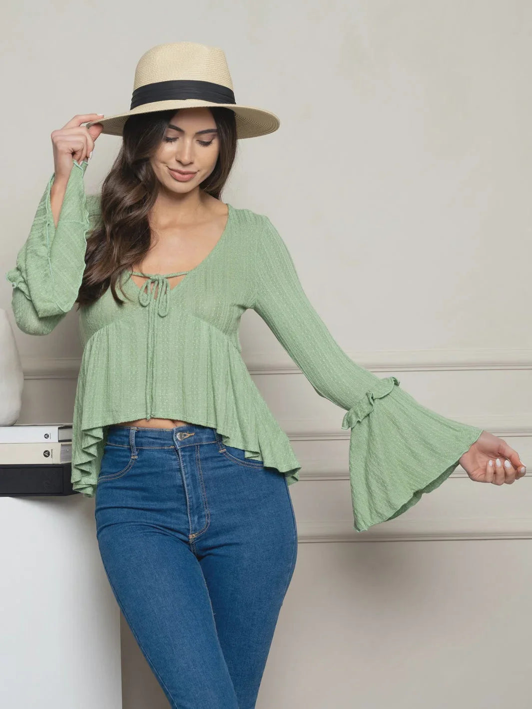 Woman in green bell-sleeved top from Shop Daisy, showcasing women’s boho chic clothing