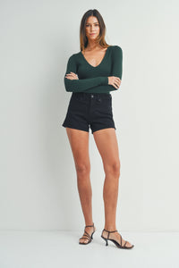 Woman in a green top and black shorts showcasing the Classic Clean Stretch Short