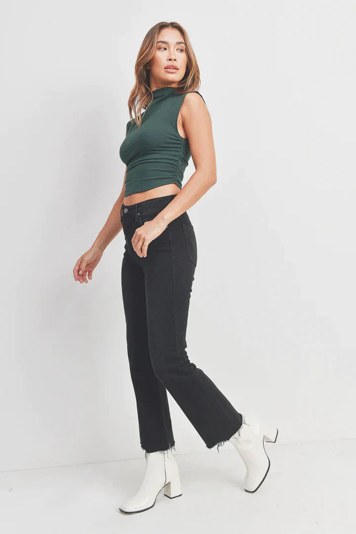 Woman in a green top and black jeans modeling Vintage Cropped Flare Denim