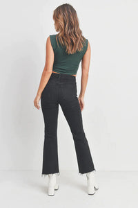 Woman wearing a green crop top and black jeans showcasing Vintage Cropped Flare Denim