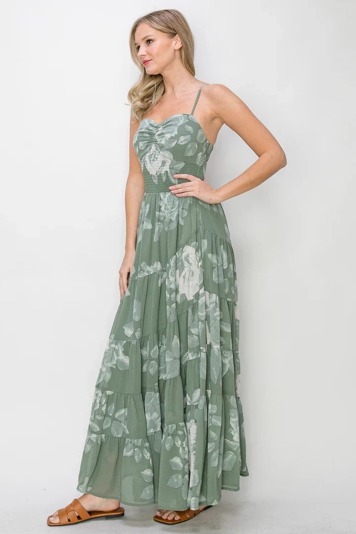 Woman in green floral print spiral tiered maxi dress