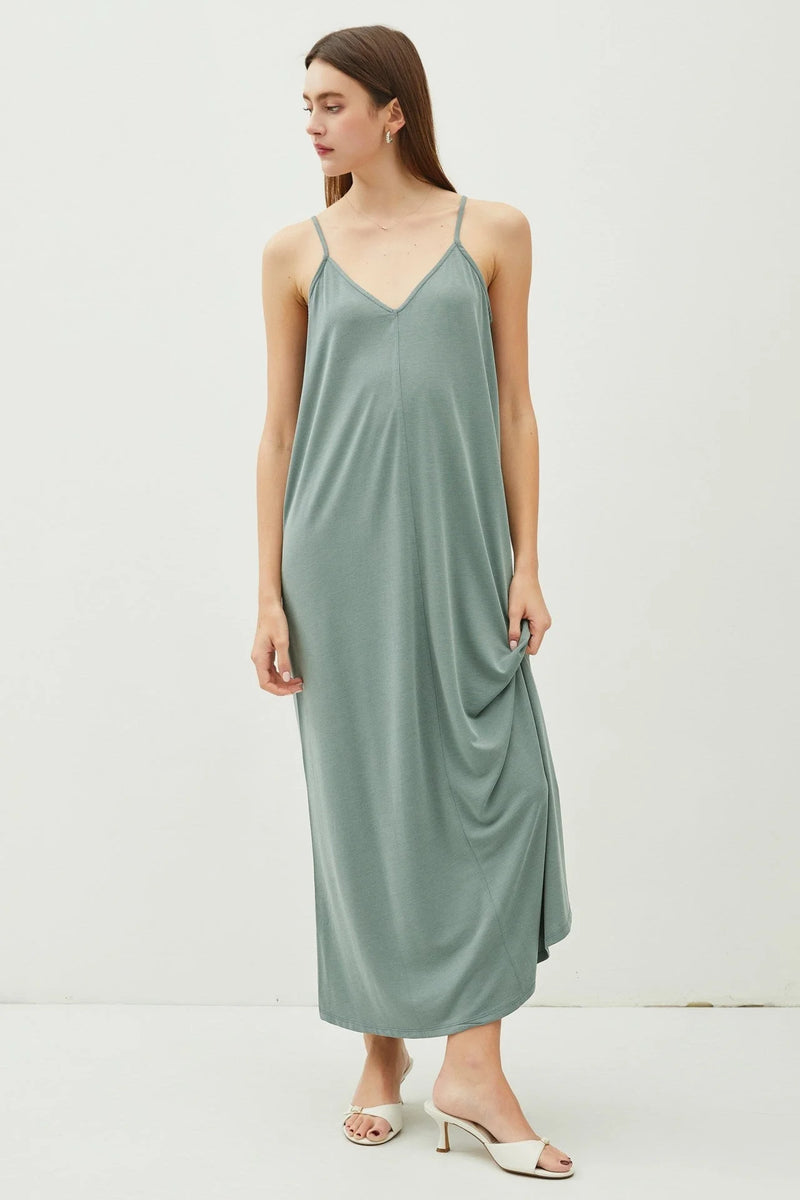 Woman wearing a green V-neck adjustable strap maxi dress showcasing an elegant strap maxi dress style