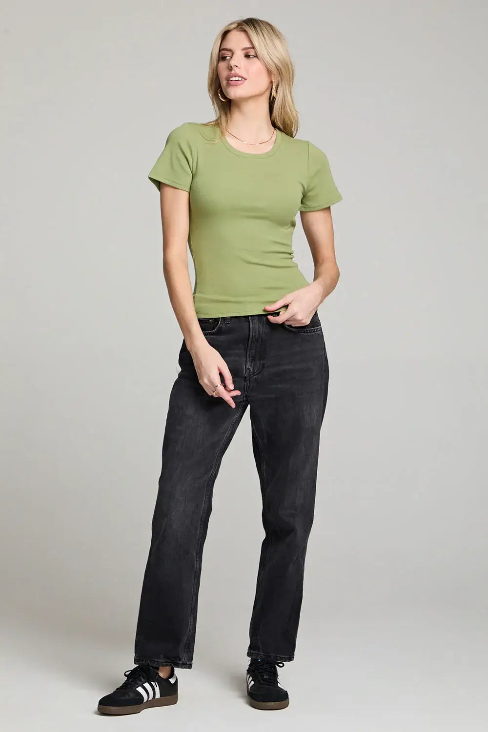 Woman in green crew neck tee and black jeans from Shop Daisy’s women’s boho chic clothing