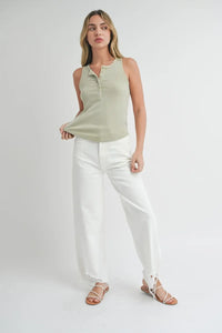 Woman in a green rib tank top and white jeans from Shop Daisy’s women’s boho chic clothing