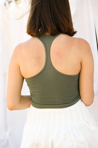 Woman in a green tank top and white skirt wearing a High Neck Racerback Brami