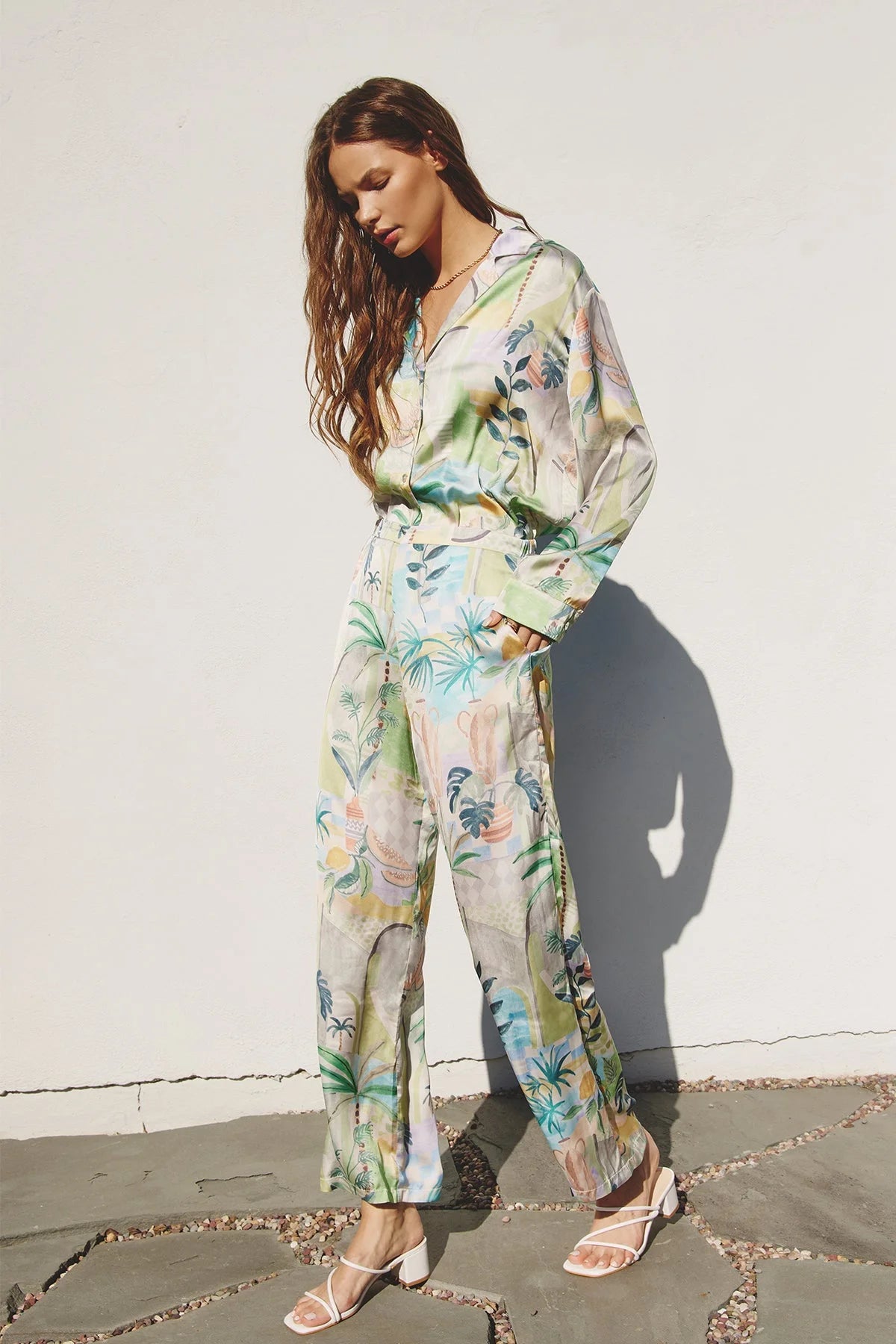 Woman in a green and white floral print jumpsuit from the OUT OF OFFICE SHIRT AND PANTS SET