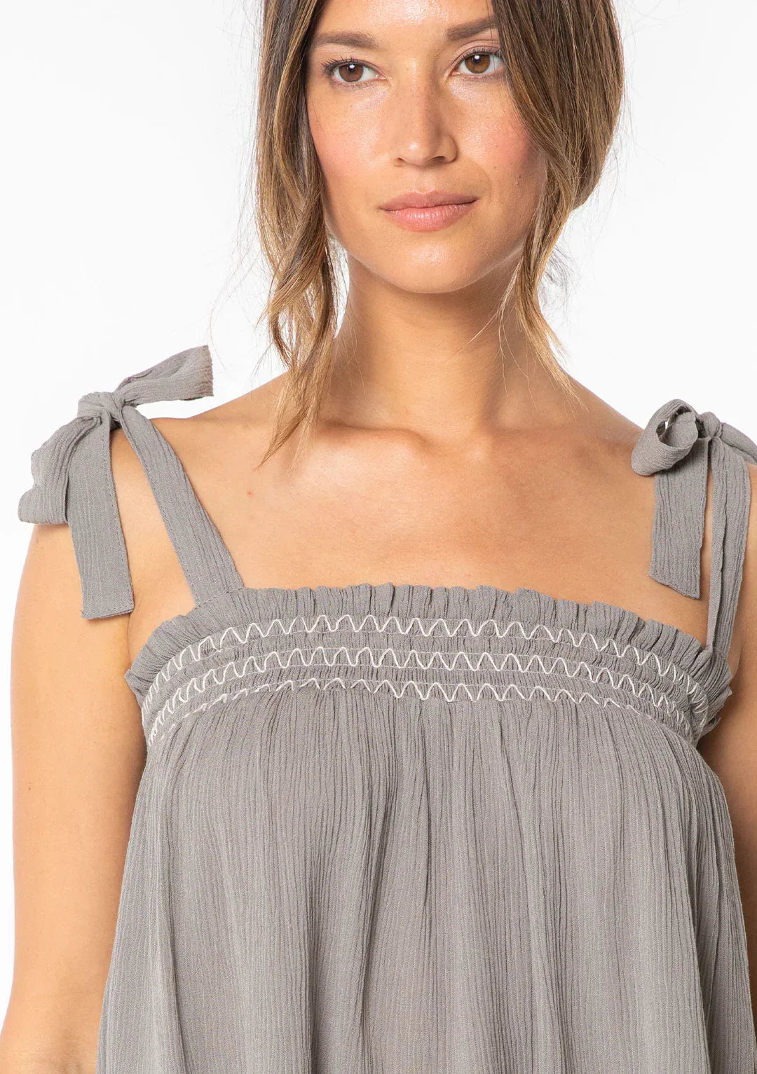 Woman modeling bohemian tie shoulder smocked tank top with tie-shoulder straps